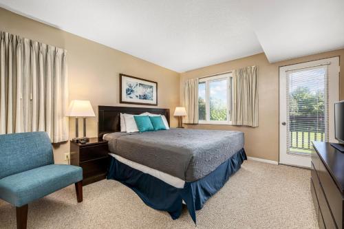 特拉弗斯城Beautiful 2BDR Loft Suite at Golf Course Condo 5549的一间卧室配有一张床、一把椅子和电视