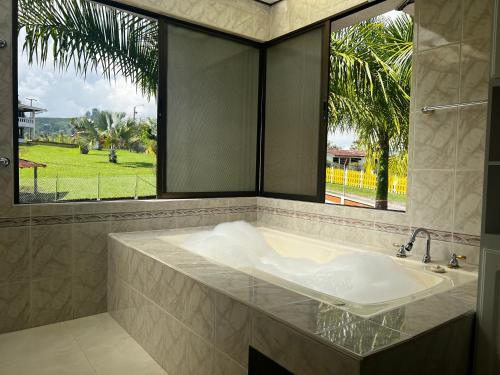 圣罗莎德卡瓦尔Hotel Casa Confort的一间带大窗户和浴缸的浴室