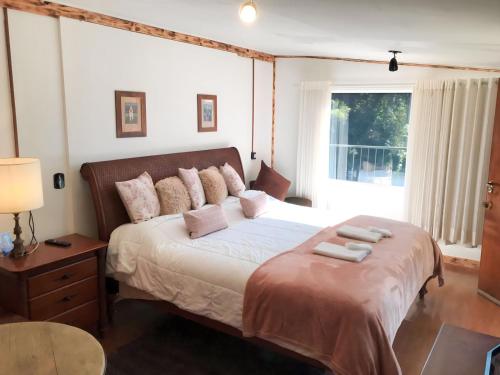 坎波斯杜若尔当Campos do Jordão Suites的一间卧室配有一张床,上面有两条毛巾