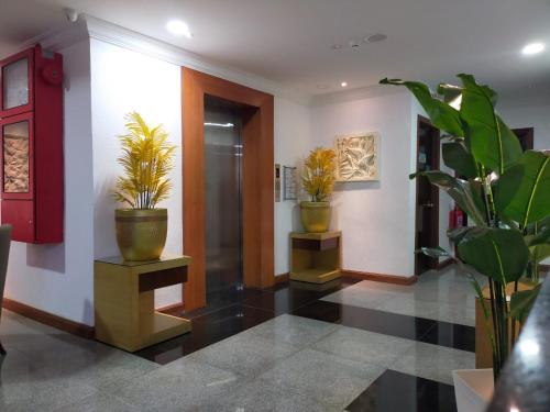 哥打巴鲁Che Wok Hotel的走廊上设有盆栽和红色的门