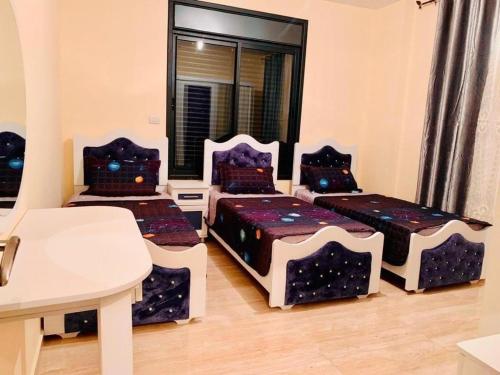 杰里科villa wardet algabal的带三张床和一张桌子的房间