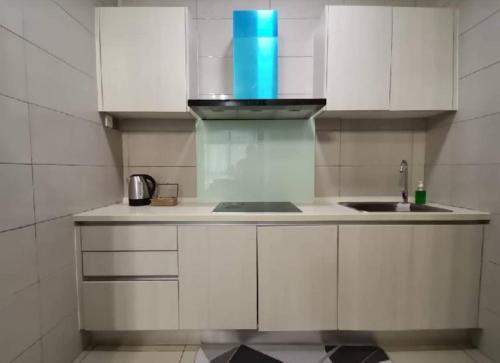 普特拉贾亚Conezion Residence Putrajaya WiFi Netflix的厨房配有白色橱柜和水槽