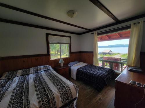 GracefieldChalet with great lake view的一间卧室设有两张床和一个美景窗户。