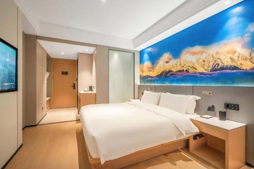 成都成都太古里IFS国金中心亚朵X酒店的一间卧室配有一张大床,墙上挂着一幅大画