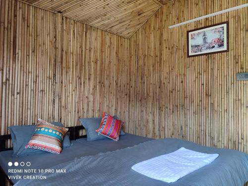 瑞诗凯诗The Jungle Mist Resort的卧室配有木墙内的一张床