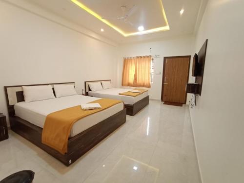 阿提贡迪Kurinji Inn的酒店客房设有两张床和电视。