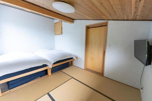 二世古Niseko肉宿屋度假屋的一间设有床、门和电视的房间
