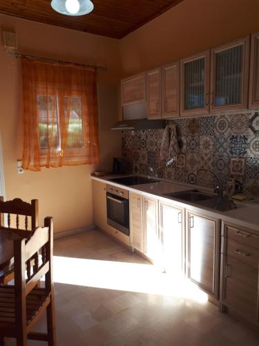 卡拉米Garneli Apartments的厨房配有水槽和炉灶 顶部烤箱