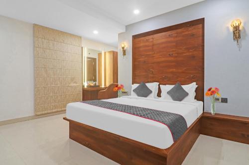 海得拉巴Super Townhouse 1185 Rcc Pride的一间卧室配有一张大床和木制床头板