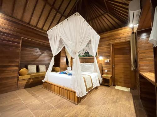 蓝梦岛格东努萨旅馆的一间卧室配有一张带天蓬的床