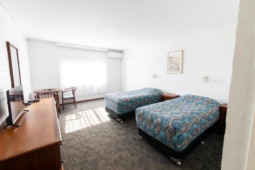 布雷默贝布雷默湾度假汽车旅馆的配有一张床和一张书桌的酒店客房