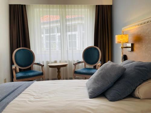 宁斯佩特文宁达尔别墅庄园酒店的一间卧室配有两把椅子、一张床和窗户