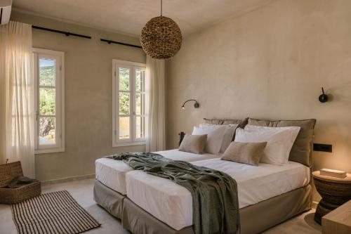 阿索斯Uberina - Olea Di Assos Villas的一间卧室设有一张大床和两个窗户。