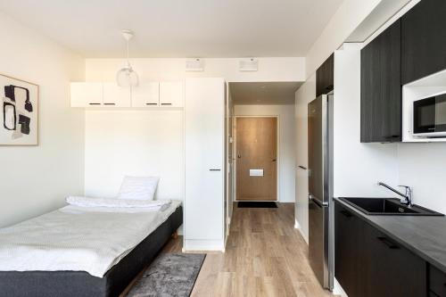 奥卢Kotimaailma Apartments Loimu VII的一间带床的小卧室和一间厨房