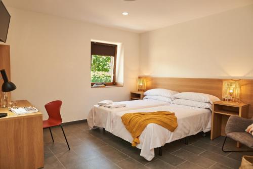 卡塞雷斯Hotel Casa Palacio Pereros的一间卧室配有一张床、一张书桌和一个窗户。
