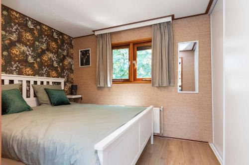 KootwijkHuize Bosrijk aan het water的一间卧室设有一张床和一个窗口