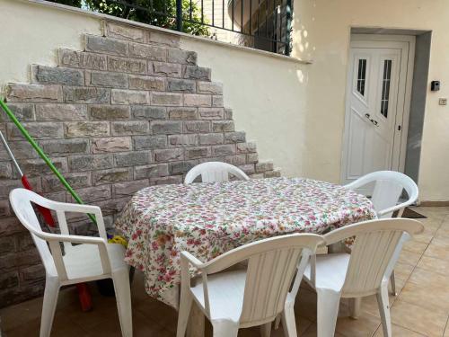 尼亚米卡尼奥纳Family Garden的桌子、四把椅子、桌子和砖墙