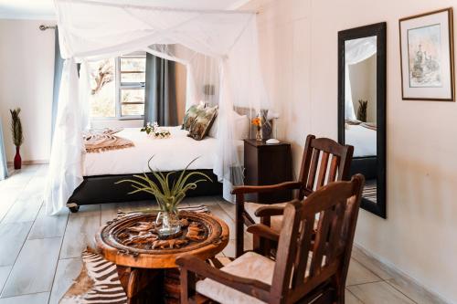 OtaviGabus Safari Lodge的卧室配有一张床和一张桌子及椅子
