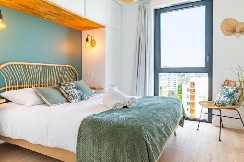 南特Loire Enchantée - Appt sur lîle de Nantes的一间卧室设有一张床和一个大窗户