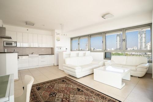 阿什杜德Luxury Apartments Blue Wave的客厅配有白色家具和大窗户