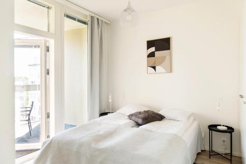 奥卢Kotimaailma Apartments Loimu V的白色的卧室设有床和窗户