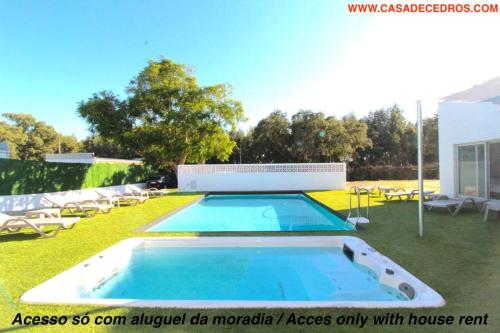 塞图巴尔Casa de cedros的一个带躺椅的庭院内的游泳池