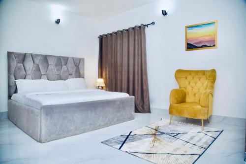 莱基Oasis Villa Lekki的一间卧室配有一张床和一把椅子