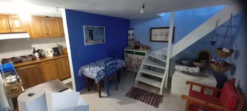 KeramídhionPilion-Unique House at the Aegean Sea的厨房设有蓝色的墙壁、桌子和楼梯。