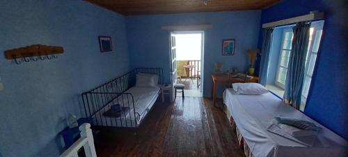 KeramídhionPilion-Unique House at the Aegean Sea的蓝色的客房设有两张床和窗户。