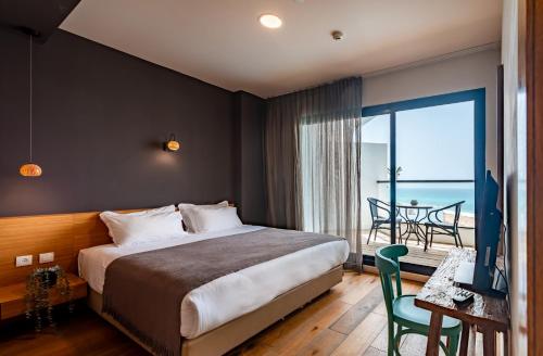 纳哈里亚Sea Life Nahariya BY Jacob Hotels的一间卧室配有一张床,享有海景