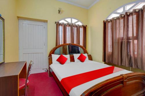 巴特那Flagship Hotel Heaven Inn的一间卧室配有一张带红色枕头的大床