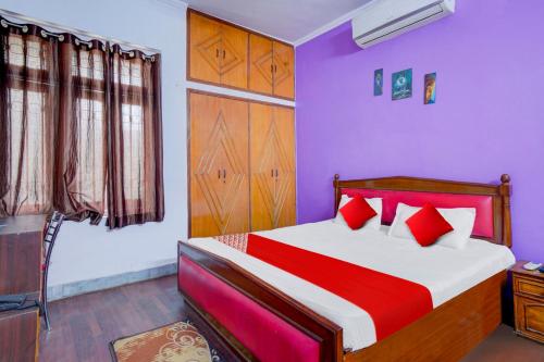 巴特那Flagship Hotel Heaven Inn的一间卧室配有一张红色和紫色墙壁的床