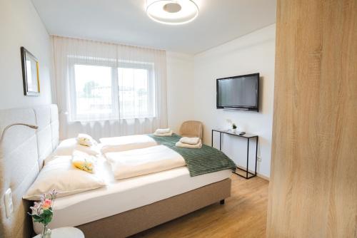蒙德塞Haus Bachinger的卧室配有一张床,墙上配有电视。