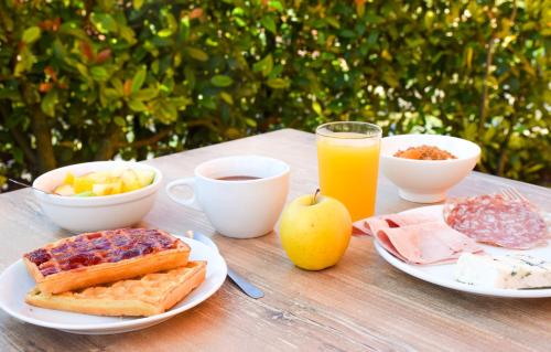米洛ibis Budget Millau Viaduc的一张桌子,上面有早餐食品和一杯橙汁