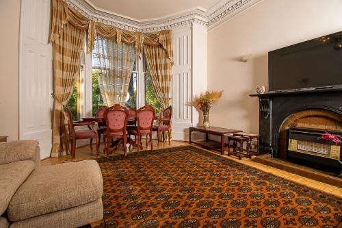 格拉斯哥Pass the Keys Traditional 5 Bed Bellahouston Glasgow Sleeps 10的客厅设有壁炉、桌子和椅子