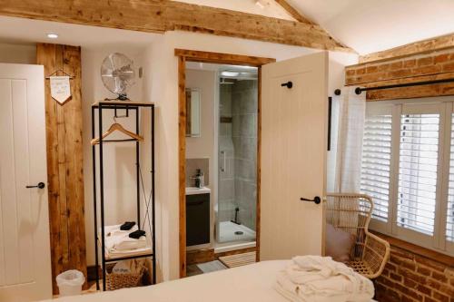 PentneyThe Threshing Barn - relaxing countryside spa break的客房设有带淋浴和盥洗盆的浴室。