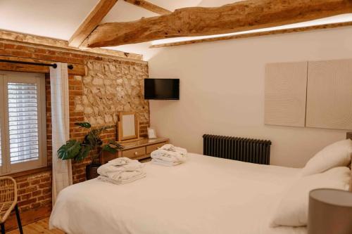 PentneyThe Threshing Barn - relaxing countryside spa break的一间卧室配有两张带毛巾的床
