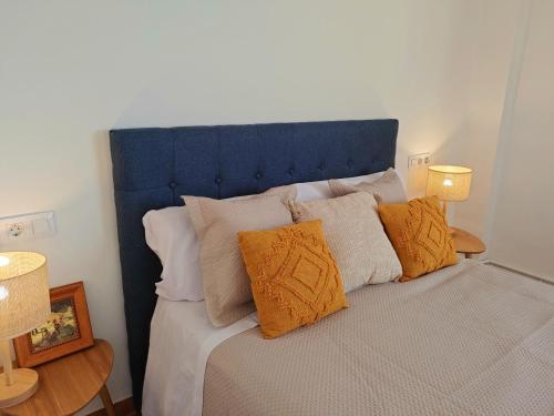 普埃尔托明加尔沃Habitaciones Mirall Rural的一张带蓝色床头板和一些枕头的床