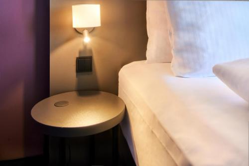 美因河畔法兰克福B&B Hotel Frankfurt-Airport的一张小桌子,旁边是房间里的床