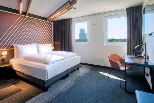 美因河畔法兰克福B&B Hotel Frankfurt-Airport的配有一张床和一张书桌的酒店客房