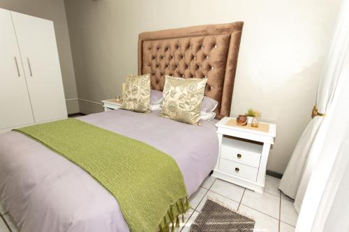 比勒陀利亚AfricaLove on Tiger的一间卧室配有一张带绿毯的大床