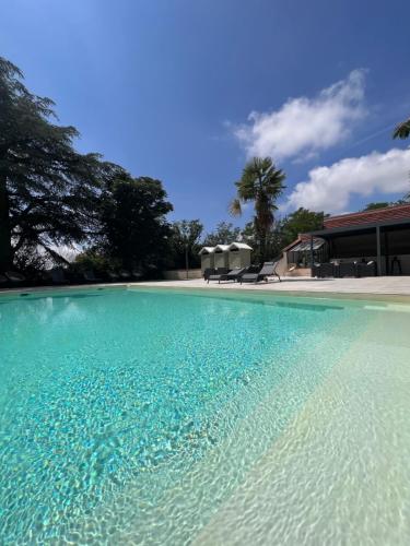 Saint-Sulpice多迈纳恩法戈酒店的一座房子前面的蓝色海水游泳池