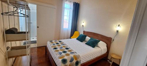 丰沙尔Chalé Funchal - City view的小卧室配有带蓝色枕头的床