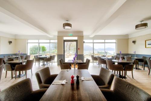 奥尼赫Onich Hotel & Lochside Beach Pods的用餐室设有桌椅和窗户。