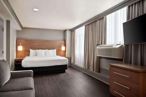 温哥华温哥华市区戴斯酒店的酒店客房,配有床和电视