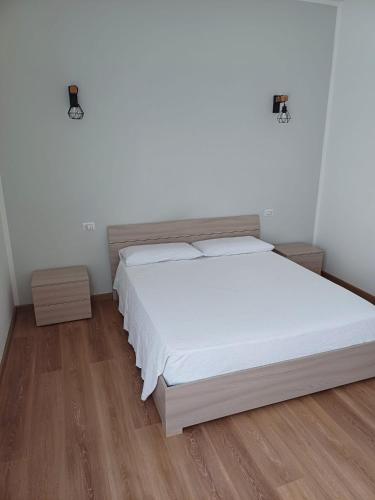 布雷西亚4 PASSI DAL CENTRO的一间卧室配有一张铺有木地板的白色床单。