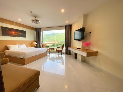 昆岛Conson Hotel的酒店客房配有一张床、一张书桌和一台电视。