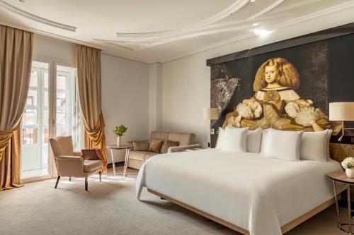 马德里Palacio de los Duques Gran Meliá - The Leading Hotels of the World的卧室配有一张大床和一幅女画