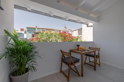 皮兰B&B Miracolo di Mare Golden House的阳台配有桌椅和鲜花。