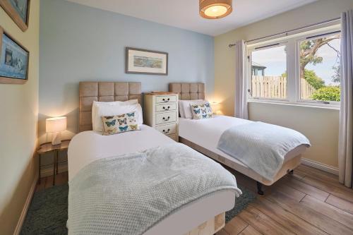 贝尔福德Host & Stay - Sandpipers的带窗户的客房内的两张床